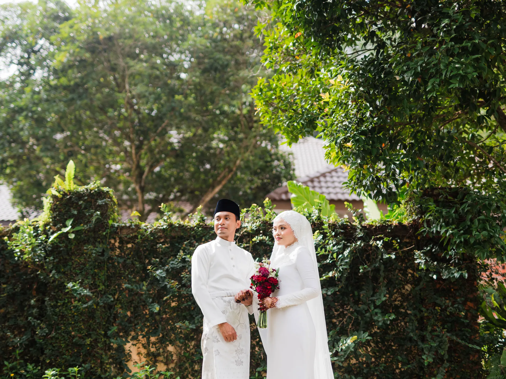 Gambar pengantin Sweetpictures berlatar belakangkan pokok hijau di laman Pengantin